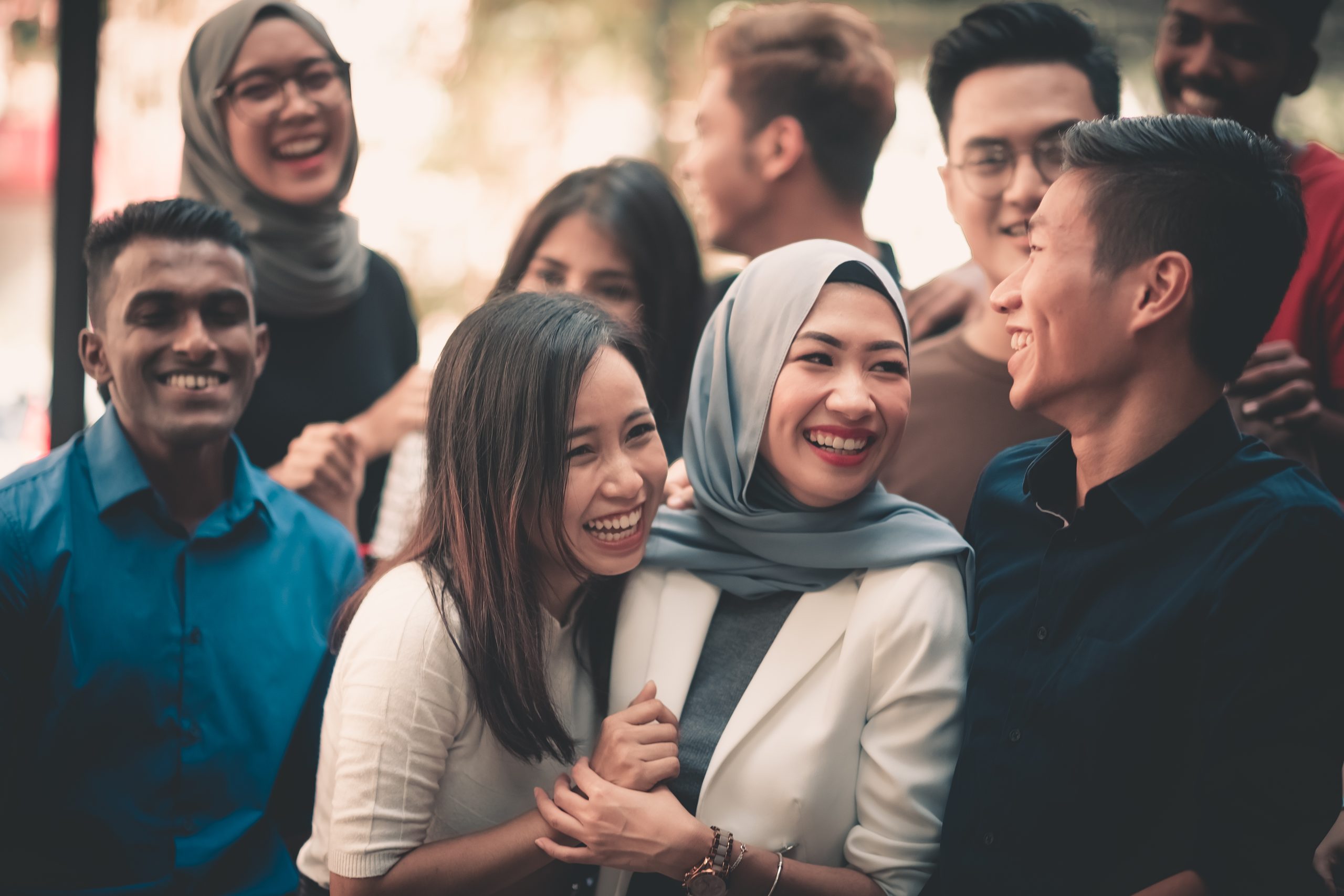 A diverse group of friends laughing together outdoors